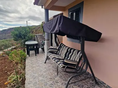 a group of chairs sitting under an umbrella on a patio at Pico Ferreira by MTH in Tábua