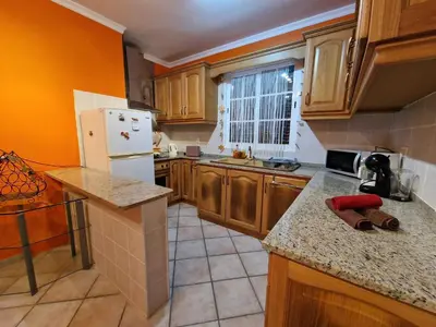 a kitchen with wooden cabinets and a white refrigerator at Pico Ferreira by MTH in Tábua