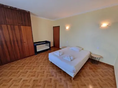 a bedroom with a white bed and a wooden floor at Pico Ferreira by MTH in Tábua