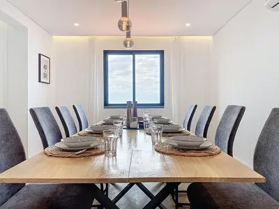 a dining room with a long wooden table and chairs at Breeze House 1 by Atlantic Holiday in Caniço