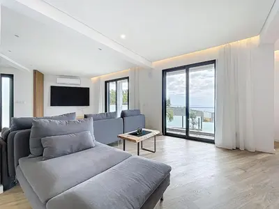 a living room with a couch and a large window at Breeze House 1 by Atlantic Holiday in Caniço