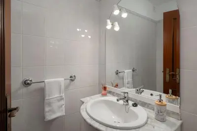 a white bathroom with a sink and a mirror at Palmasol by An Island Apart in Calheta
