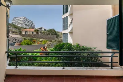a person sitting on a balcony of a building at Palmasol by An Island Apart in Calheta
