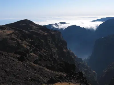 a view of a mountain range with clouds in the distance at Capuchinhas Apartment in Funchal