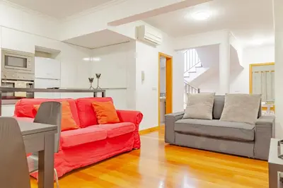 a living room with a red couch and a chair at Capuchinhas Apartment in Funchal