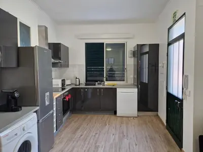 a kitchen with stainless steel appliances and a large window at Machico Villas Accommodation with Private Parking in Machico