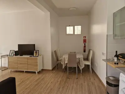 a living room with a dining room table and a television at Machico Villas Accommodation with Private Parking in Machico