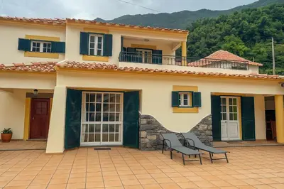 a house with two benches in front of it at Boaventura Cottage-Casa de Campo in Serra de Água
