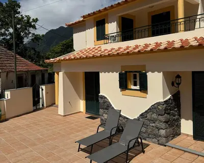 a house with two chairs on a patio at Boaventura Cottage-Casa de Campo in Serra de Água