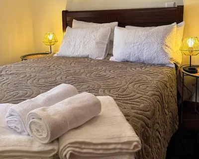 a bedroom with a bed with towels on it at Boaventura Cottage-Casa de Campo in Serra de Água