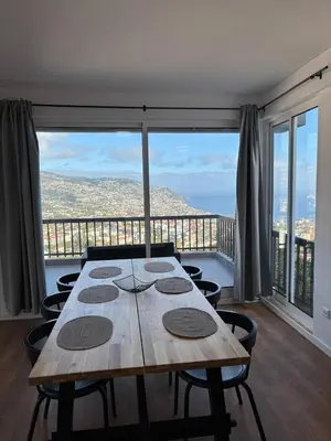 a wooden table in a room with a large window at Casa Barcelos in Funchal