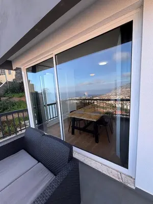 a balcony with a bench and a table with a view at Casa Barcelos in Funchal