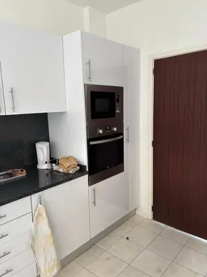 a kitchen with white cabinets and a microwave at Casa Barcelos in Funchal