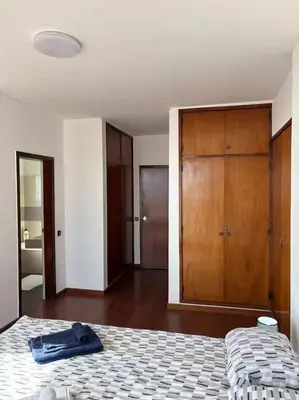a bedroom with a bed and a wooden cabinet at Casa Barcelos in Funchal