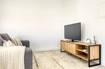 a living room with a television on a wooden stand at Casa da Tia Celeste I, a Home in Madeira in Ponta do Sol