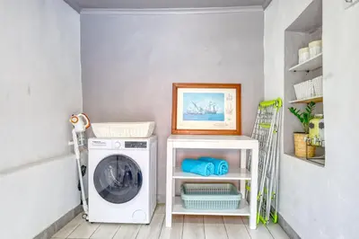 a laundry room with a washing machine and a picture at Casa da Tia Celeste I, a Home in Madeira in Ponta do Sol