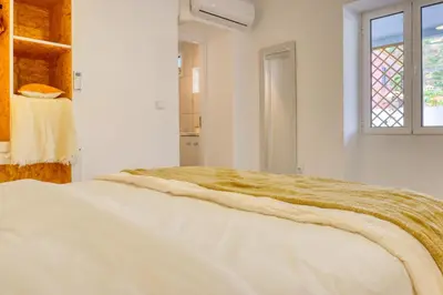a white bedroom with a bed and a window at Casa da Tia Celeste II, a Home in Madeira in Ponta do Sol