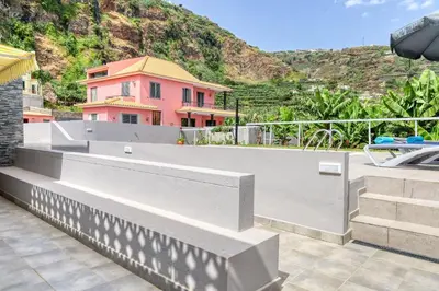 a pink house with a hill in the background at Casa da Tia Celeste II, a Home in Madeira in Ponta do Sol