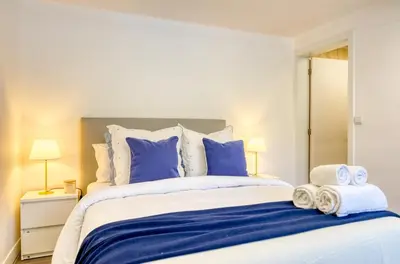 a bedroom with a large bed with blue and white pillows at Casa da Tia Celeste III, a Home in Madeira in Ponta do Sol