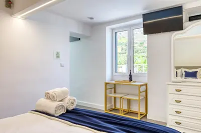 a bedroom with a bed and a dresser and a window at Casa da Tia Celeste III, a Home in Madeira in Ponta do Sol