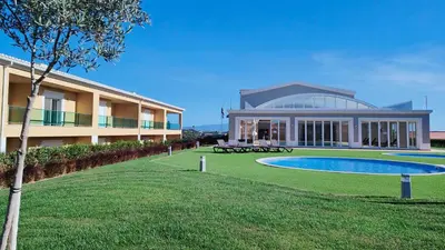 a building with a swimming pool in front of a building at Boavista Golf and Spa Resort - Bayview Bellavista in Lagos