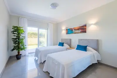 a bedroom with two beds and a potted plant at Boavista Golf and Spa Resort - Bayview Bellavista in Lagos