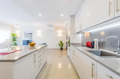 a white kitchen with white cabinets and a sink at Boavista Golf and Spa Resort - Bayview Bellavista in Lagos