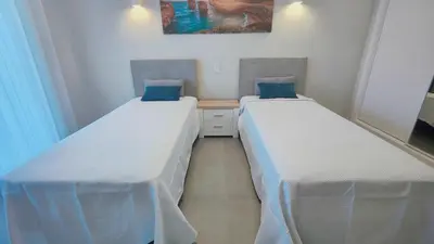 two beds in a small room withermottermottermott at Boavista Golf and Spa Resort - Bayview Bellavista in Lagos