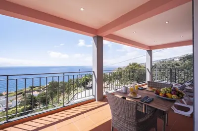 a balcony with a table with a bowl of fruit on it at Casa do Miradoro in Santa Cruz