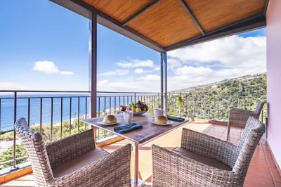 a dining room with a table and chairs on a balcony at Casa do Miradoro in Santa Cruz