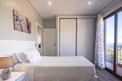 a bedroom with a bed and a large window at Casa do Miradoro in Santa Cruz