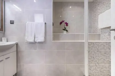 a bathroom with a shower with white tiles at Casa do Miradoro in Santa Cruz