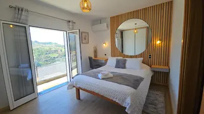 a bedroom with a bed with a mirror and a window at Top Floor in Flor do Campo - Santana in Santana