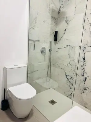 a white bathroom with a toilet and a shower at Casa Marguerite Gym and Hammam by Rentallido in Caniço