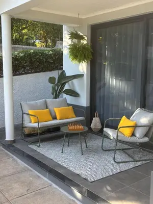 a patio with a couch and two chairs and a table at Casa Marguerite Gym and Hammam by Rentallido in Caniço