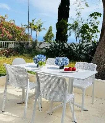 a white table and chairs with flowers on it at Casa Marguerite Gym and Hammam by Rentallido in Caniço