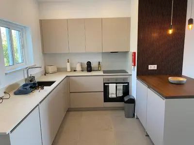 a kitchen with white cabinets and a stove top oven at The Ocean View Luz in Luz