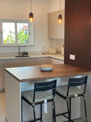 a kitchen with two chairs sitting at a counter at The Ocean View Luz in Luz