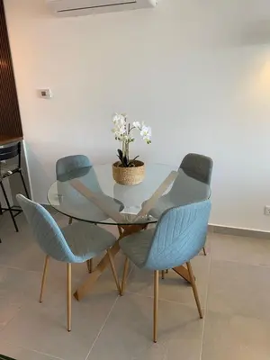 a glass table with three chairs and a plant on it at The Ocean View Luz in Luz