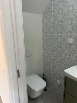 a bathroom with a toilet and a tiled wall at The Ocean View Luz in Luz