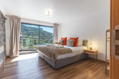 a bedroom with a bed with a large window at Julianas House 1 by Atlantic Holiday in Campanário