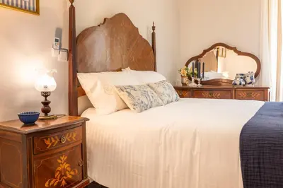 a bedroom with a large bed and a dresser with a mirror at Casa da Bisa, By OP in São Vicente