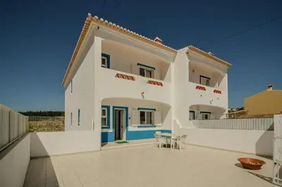 a large white building with a patio in front of it at FLH Budens Duplex with Terrace in Vila do Bispo