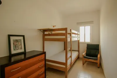 a bedroom with bunk beds and a desk and a chair at FLH Budens Duplex with Terrace in Vila do Bispo