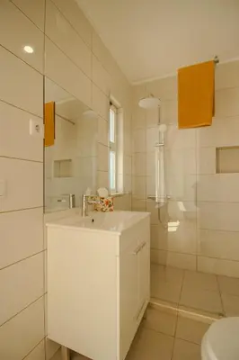 a white bathroom with a sink and a shower at FLH Budens Duplex with Terrace in Vila do Bispo