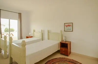 a bedroom with two white beds and a window at FLH Budens Duplex with Terrace in Vila do Bispo
