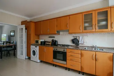 a kitchen with wooden cabinets and a washing machine at FLH Budens Duplex with Terrace in Vila do Bispo