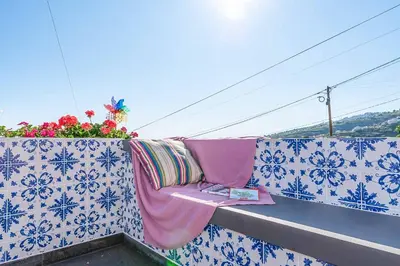 a balcony with a blanket and a book on it at Casa das Orquideas in Estreito da Calheta