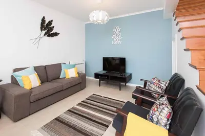a living room with a couch and a television at Casa das Orquideas in Estreito da Calheta