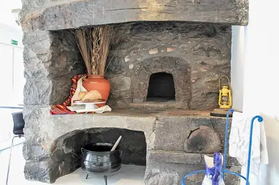 a stone oven with a pot and a vase at Casa das Orquideas in Estreito da Calheta